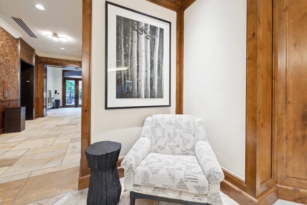 Lobby seating and wall finishes at Aspen Mountain Residences with framed Aspen tree artwork.