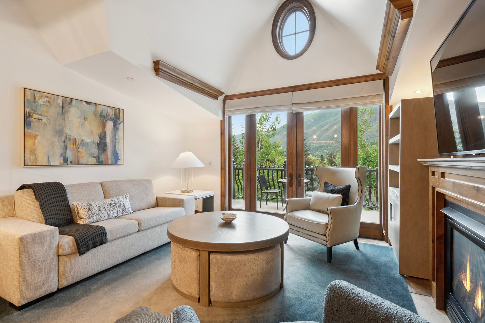 Aspen Mountain Residences 1 Renovated vaulted living room at Aspen Mountain Residences with fireplace, seating and mountain views.