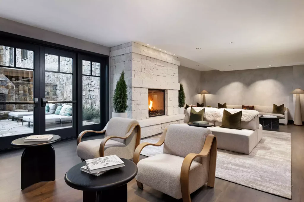 Renovated Four Seasons Vail spa lounge with stone fireplace and curved lounge seating