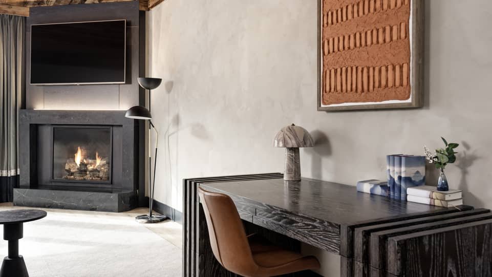 Renovated Four Seasons Vail suite desk and fireplace with textured wall finish