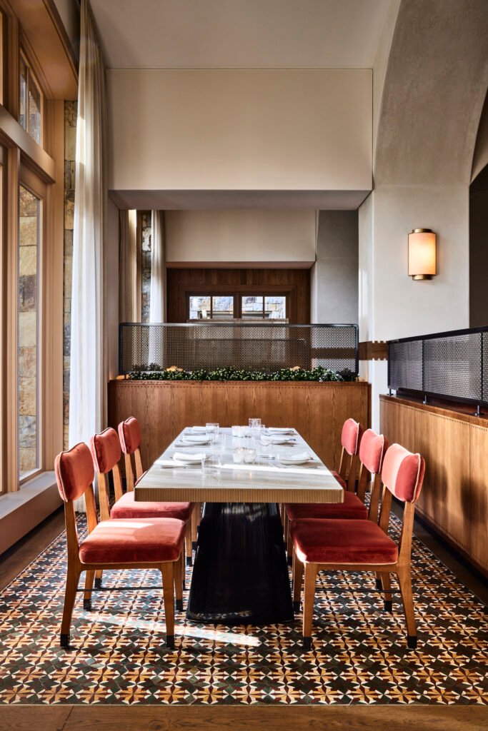 Completed Tavernetta Vail dining area with red upholstered chairs, tall windows, and patterned tile floor